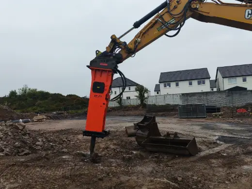 NPK hydraulic breaker on a Cat excavator at a housing site
