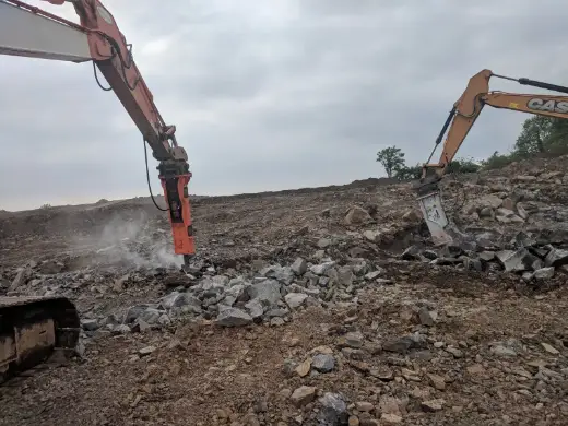 Excavator and breaker clearing broken ground