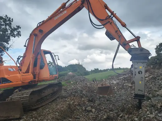 Rock breaker working ground on a site clearance