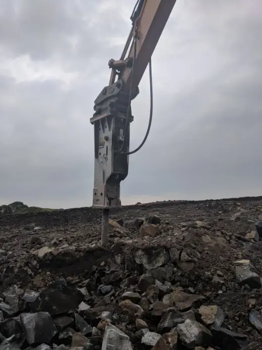 Hydraulic breaker chiselling into rock