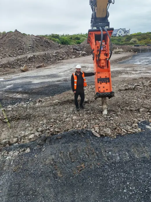 Hydraulic breaker on site shown against an operator for scale