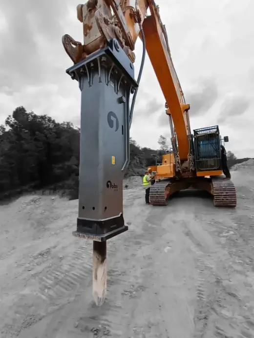 Breaker working through rock with dust rising