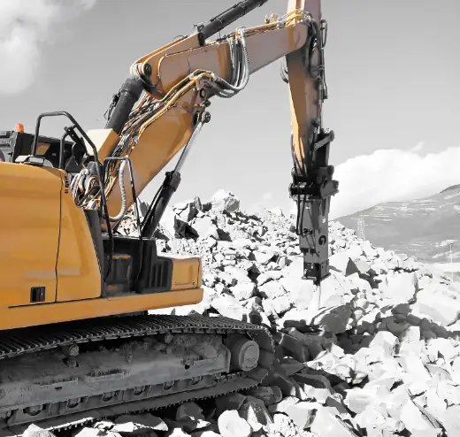 Excavator and hydraulic breaker on broken stone